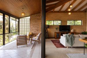 an open living room with a brick wall at Tranquil mountain escape with bushland views in Mount Tamborine