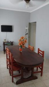 a wooden table with chairs and a vase of flowers on it at Casa del Arbol in San Fernando del Valle de Catamarca +5 photos