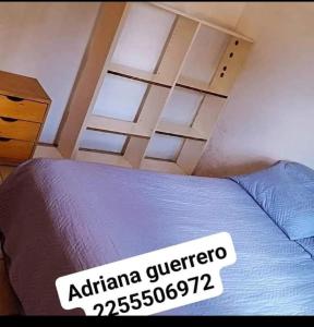 a bedroom with a bed with a sign on it at Mí esquina departamentos familiares in Villa Gesell