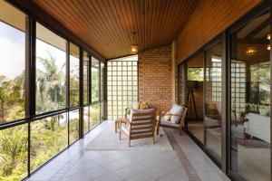 a living room with large windows and a table and chairs at Tranquil mountain escape with bushland views in Mount Tamborine