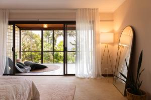a bedroom with a bed and a sliding glass door at Tranquil mountain escape with bushland views in Mount Tamborine