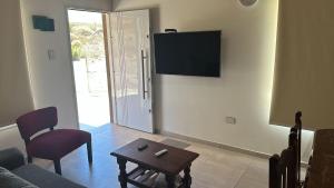 a living room with a couch and a table and a tv at Duplex en villa el chocon LO DE CARLITOS in Villa El Chocón