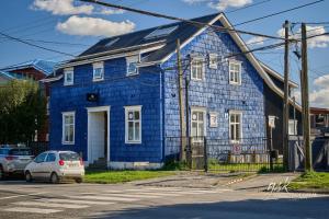 ein blaues Haus mit einem davor geparkt in der Unterkunft Dolce Vita - Alojamiento Histórico in Puerto Varas