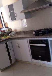 a kitchen with white cabinets and a black oven at Apartamento cerca Bocagrande in Cartagena de Indias