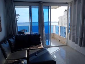 a living room with a couch and a large window at Apartamento cerca Bocagrande in Cartagena de Indias