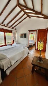 ein Schlafzimmer mit einem großen Bett und einem Tisch in der Unterkunft Refugio Khalma de la Montaña in Villa de Leyva