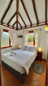 Schlafzimmer mit einem großen weißen Bett und Fenstern in der Unterkunft Refugio Khalma de la Montaña in Villa de Leyva