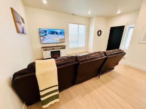 un sofá de cuero marrón en una sala de estar con chimenea en New 3BR Home w Garage Near BYU-Idaho, en Rexburg