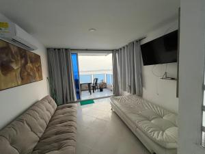 a living room with a couch and a view of the ocean at Apartamento cerca Bocagrande in Cartagena de Indias