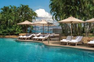 a swimming pool with lounge chairs and umbrellas at Renaissance Hong Kong Harbour View Hotel in Hong Kong