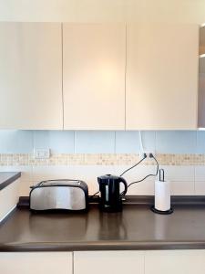 拉塞雷纳Apartment steps from the beach, 3D-2B and elevator的厨房里有白色橱柜、烤面包机和另一台烤面包机