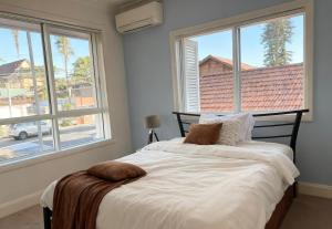Burwood Family Guest Home في سيدني: غرفة نوم بها سرير ونافذة كبيرة