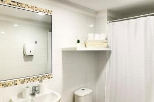 拉塞雷纳Apartment steps from the beach, 3D-2B and elevator的一间白色浴室，配有洗手池和镜子。 更多7张照片