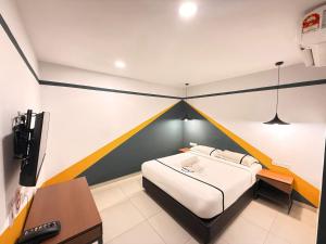 a room with a bed and a desk in it at Smile Hotel Klang Bukit Tinggi in Kampong Telok Gadong Besar