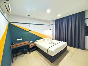a bedroom with a bed and a desk in it at Smile Hotel Klang Bukit Tinggi in Kampong Telok Gadong Besar