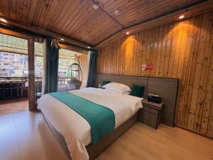 Ένα ή περισσότερα κρεβάτια σε δωμάτιο στο Fenghuang Ancient Town Fuyuan Riverside Homestay