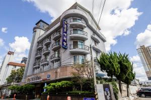 ein weißes Gebäude mit einem blauen Schild darauf in der Unterkunft Jeonju Arirang in Jeonju