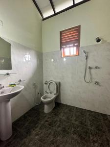 a bathroom with a toilet and a sink and a shower at Calm Casita Luxury Villa in Matara in Matara