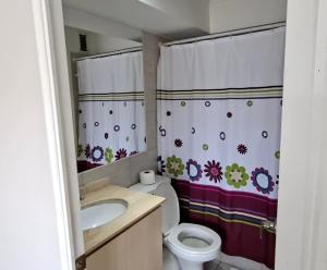 une salle de bain avec toilettes, lavabo et rideau de douche dans l'établissement Depto Puertas del Mar La Serena, à La Serena