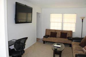 uma sala de estar com um sofá e uma TV de tela plana em Luxurious Pool and Spa Home with optional Studio Apts em Durham