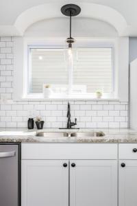 eine weiße Küche mit Spüle und Fenster in der Unterkunft Modern 3BR w Yard Garage in Columbus