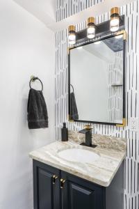 ein Badezimmer mit Waschbecken und Spiegel in der Unterkunft Modern 3BR w Yard Garage in Columbus + 19 Fotos