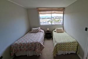 deux lits dans une petite pièce avec une fenêtre dans l'établissement Depto Puertas del Mar La Serena, à La Serena