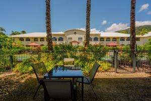 a table and chairs in front of a building at Mango Lagoon Resort & Wellness Spa in Palm Cove