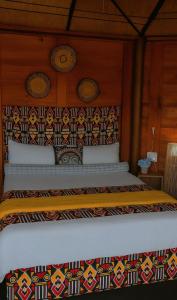 a bed with a blanket on top of it at African Hut Camp - Free Massage With Sauna And Hot Tub in Tulbagh