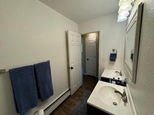 ein weißes Badezimmer mit Waschbecken und Spiegel in der Unterkunft Midnight Sun - Near Airport and Shopping in Anchorage + 22 Fotos