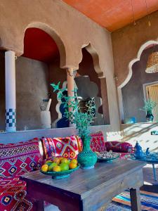Ein Tisch mit Obstschalen auf einem Sofa in der Unterkunft Dar Zitoune - Authentic Stay in Tagounite in Tagounite