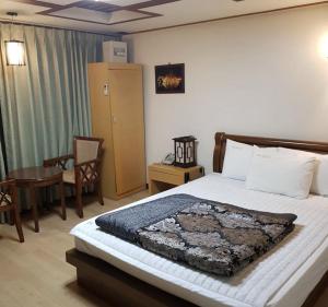 ein Schlafzimmer mit einem Bett, einem Tisch und einem Stuhl in der Unterkunft Jeonju Arirang in Jeonju + 28 Fotos
