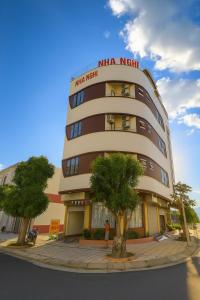 a woman standing in front of a building at Dũng Quyến Homestay in Danang