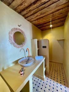 ein Badezimmer mit einem Waschbecken auf einer Ablage mit einem Spiegel in der Unterkunft Dar Zitoune - Authentic Stay in Tagounite in Tagounite + 43 Fotos