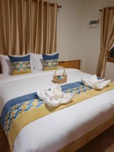a bed with a basket and white flowers on it at Pai Pavilion in Pai