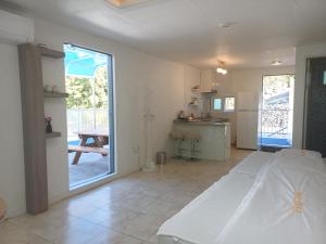 a bedroom with a bed and a kitchen with a table at Melodia Pension in Geoje 