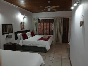 a bedroom with two beds and a ceiling fan at Aero Garden Ensuite in Johannesburg +19 photos