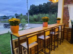 a wooden bar with stools and orange vases at Pai Pavilion in Pai