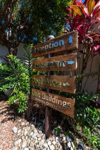a directional sign in the middle of a garden at Mango Lagoon Resort & Wellness Spa in Palm Cove