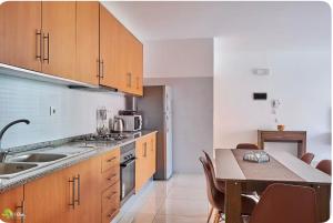 a kitchen with wooden cabinets and a table with chairs at Apartamentos Ramos 3 in Santa Maria