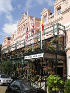 een roze gebouw met Amerikaanse en Franse vlaggen erop bij Norfolk Royale Hotel in Bournemouth