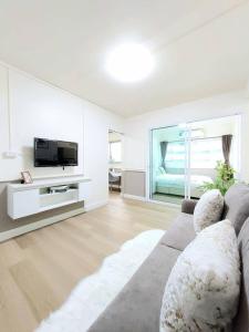 Una sala de estar con un sofá y un televisor. en Impact poppula P1 by เจี๊ยบ, en Thung Si Kan