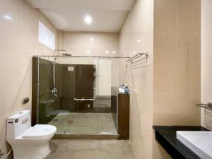 a bathroom with a shower and a toilet and a sink at Aura Beachfront Hotel - Apartment in Da Nang +61 photos