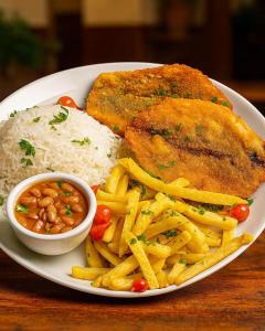 a plate of food with chicken rice and french fries at Hotel Pousada Sol Nascente Mafraa in Mafra