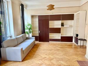 a living room with a couch and wooden floors at Spacious Classical Style Apartment in Vienna