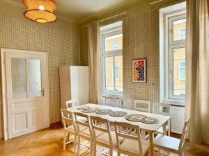 a dining room with a white table and chairs at Spacious Classical Style Apartment in Vienna +13 photos