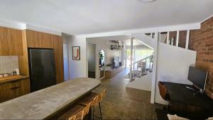 a living room with a couch and a staircase at Emerald Break- The Perfect Coastal Escape in Emerald Beach