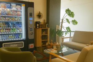 a living room with a refrigerator filled with drinks at The Post Hotel in Porirua
