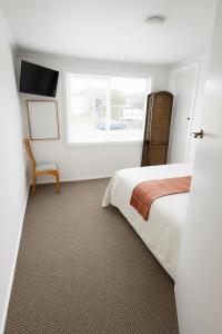 a bedroom with a bed and a window at Top of Tyne - Peace, Comfort & Local Connection in Oamaru