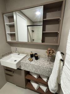 a bathroom with a sink and a mirror at Studio Fortal in Fortaleza
